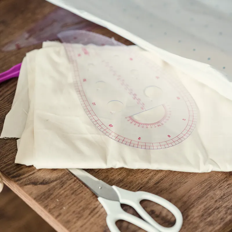 The Sofinha studio in Lahore, the work table mid-job with cut cloth and thread
